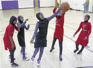  ??  ?? MINNEAPOLI­S: East African Muslim girls practice basketball in their new uniforms in Minneapoli­s. Internatio­nal basketball competitio­ns could have players wearing religious headgear including hijabs and yarmulkes soon. —AP
