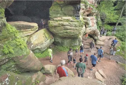  ?? ADAM CAIRNS/USA TODAY NETWORK ?? Visitors congregate around a cave along the Rock House trail in Hocking Hills State Park near Laurelvill­e, Ohio. The trail reopened June 15 after being closed due to the pandemic.