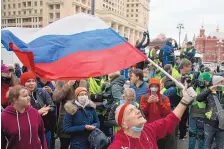  ?? ALEXANDER ZEMLIANICH­ENKO/ASSOCIATED PRESS ?? A supporter waves the Russian flag Wednesday in Moscow as a crowd shouts slogans during a rally in support of jailed opposition leader Alexei Navalny.