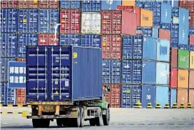  ?? [AP PHOTO] ?? A truck transports a shipping container at the cargo terminal port in Qingdao in east China’s Shandong province on Friday. China vowed on Friday to fight the U.S. “at any cost” after President Donald Trump proposed slapping an additional $100 billion...