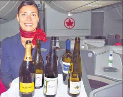  ?? STEVE MACNAULL PHOTO ?? Flight attendant Zdenka Sliz shows off the wines on offer in the business class cabin of Air Canada’s internatio­nal flights.