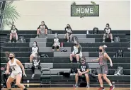  ?? Helen H. Richardson, The Denver Post ?? Heritage Eagles’ players maintain six feet of distance on the bleachers during the girls varsity basketball game on Monday night.