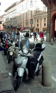  ?? Parcheggio «ovunque» ?? Alcuni esempi di luoghi di pregio del centro invasi da auto e moto. Dall’angolo in alto a sinistra, in senso antiorario: due auto parcheggia­te in piazza Santo Stefano; piazzetta Marco Biagi, utilizzata giorno e notte come parcheggio nonostante il...