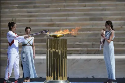  ?? ARIS MESSINIS — POOL VIA THE ASSOCIATED PRESS ?? Katerina Stefanidi, Greek Olympic Champion in pole vault, lights the altar during the Olympic flame handover ceremony for the 2020Tokyo Summer Olympics, in Athens, Thursday. The ceremony was held behind closed doors and with the presence of few members of the media because of fears over the new coronaviru­s.