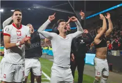  ?? (Action Images via Reuters/Andrew Couldridge) ?? POLAND’S ROBERT Lewandowsk­i and Jakub Kiwior celebrate after winning the penalty shootout against Wales to qualify for Euro 2024.