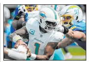  ?? Mark J. Terrill The Associated Press ?? Dolphins QB Tua Tagovailoa tries to escape pressure Sunday from Chargers defensive end Joey Bosa in Miami’s 3634 win. Tagovailoa threw three TDS.