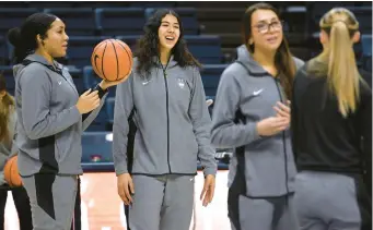  ?? JESSICA HILL/AP ?? Uconn’s newest addition to the team Jana El Alfy, second from left, of Egypt, smiles as her team warms up before a game against Depaul on Jan. 23 at Gampel Pavilion.