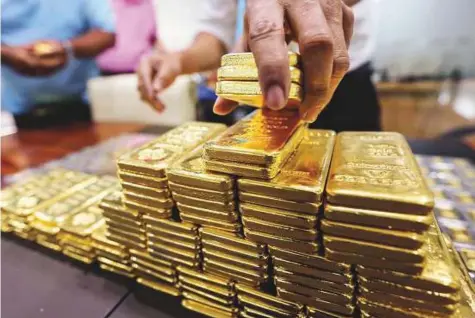  ?? Bloomberg ?? One kilogram gold bars at YLG Bullion Internatio­nal Co headquarte­rs in Bangkok, Thailand. Commoditie­s got cheaper through much of the second quarter, adding to several years of mediocre-to-weak performanc­e, with gold and silver bearing the brunt.