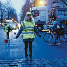  ?? Foto: Jörg Carstensen, dpa ?? Schülerlot­sin Ava sichert eine Straße in Berlin. Deutschlan­dweit engagieren sich rund 50.000 Kinder und Erwachsene als Schülerlot­sen.