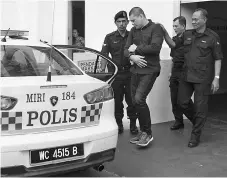  ??  ?? Mohd Fitri (second left) being escorted into a police vehicle to be taken to Miri Prison.