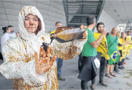  ?? REUTERS ?? A Greenpeace activist pours oil on her hand during a demonstrat­ion outside the Palais des Congres after they disrupted Total’s annual shareholde­rs meeting in protest against the French oil and gas major’s quest to the drill in the ecological­ly...