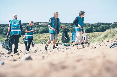  ?? ?? TIDY WORK: Volunteers take part in a previous Marine Conservati­on Society’s Great British Beach Clean and survey.