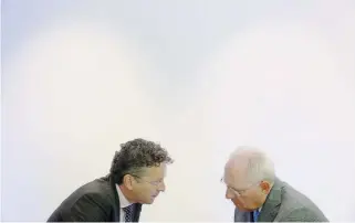  ??  ?? Eurogroup President Jeroen Dijsselblo­em (l) and German Finance Minister Wolfgang Schaeuble speak before a meeting of eurozone finance ministers in Luxembourg which produced an agreement to release loans and detail debt relief.