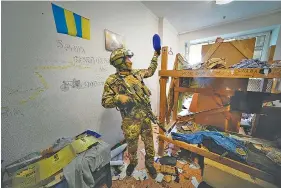  ?? AP PHOTO ?? A Russian soldier walks inside the Ukraine’s Azov Regiment base adorned with the unit’s emblems in Yuriivka resort settlement on the coast of Azov Sea not far from Mariupol, in territory under the government of the Donetsk People’s Republic, eastern Ukraine, on Wednesday.