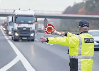  ?? FOTO: DPA ?? Ein Polizeibea­mter winkt an der A 10 einen Lastwagen zur Kontrolle raus: Bei jedem zweiten in Deutschlan­d kontrollie­rten Lastwagen finden die Beamten einen Grund zur Beanstandu­ng.