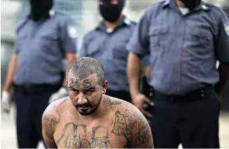  ?? José Cabezas - 12.out.2017/Reuters ?? Membro de gangue é escoltado em chegada a prisão de segurança máxima, em El Salvador