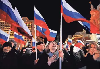  ?? FOTO: AP ?? Auf dem Manezhnaya-Platz nahe des Kremls schwenken Wähler russische Flaggen.