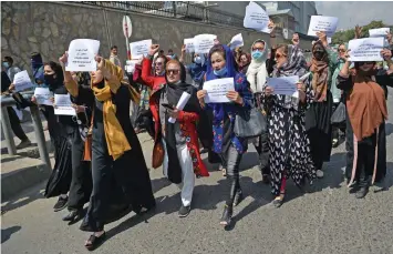  ?? — AFP ?? Afghan women take part in a protest march for their rights under the Taliban rule in the downtown area of Kabul on Friday.