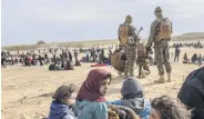  ??  ?? Civilians from the Daesh holdout of Baghouz wait at an area held by U.S.-backed YPG/PKK terrorists, in Deir el-Zour, March 5, 2019.