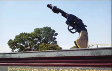  ?? GARYCYCLES­8/FLICKR ?? A statue of a revolver with a knotted barrel near Phnom Penh’s Japanese Friendship Bridge. The statue was inaugurate­d in 1999 to symbolise government efforts to get rid of illegal weapons.