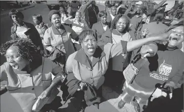  ?? Ben Curtis
Associated Press ?? MEMBERS OF THE AFRICAN National Congress Women’s League sing in support of former South African President Nelson Mandela outside the Pretoria hospital where he is being treated.