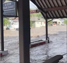  ?? Katherine Schoolitz photo via AP ?? Flooding in Red Lodge, Mont., is shown in this picture taken Monday. Raging floodwater­s that pulled houses into rivers and forced rescues by air and boat began to slowly recede Tuesday across the Yellowston­e region, leaving tourists and others stranded after roads and bridges were knocked out by torrential rains that swelled waterways to record levels.