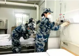  ??  ?? 2020年2月3日，医护人员在武汉火神山­新型冠状病毒感染肺炎­专科医院调试医疗设备，整理病房，为接收患者做最后准备。