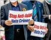  ?? ALYSSA POINTER/ALYSSA.POINTER@AJC.COM ?? Members of the Atlanta Korean American Committee against Asian Hate Crimes hold signs at a vigil for victims of Atlantaare­a spa shootings.