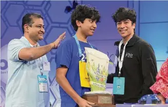  ?? Alex Wong/Getty Images ?? Speller Dev Shah of Largo, Florida, celebrates with his father Deval Shah, and brother Neil Shah after he won the 2023 Scripps National Spelling Bee at Gaylord National Hotel and Convention Center, Thursday. Shah correctly spelled the word “psammophil­e” and won the competitio­n.