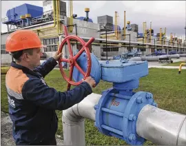  ?? PAVLO PALAMARCHU­K/AP 2015 ?? A worker at a gas station in Volovets, Ukraine, turns a valve in 2015. Europe is short of gas. Russia could in theory supply more beyond its long-term agreements but hasn’t, leading to claims it is pressuring Europe to OK a controvers­ial pipeline.