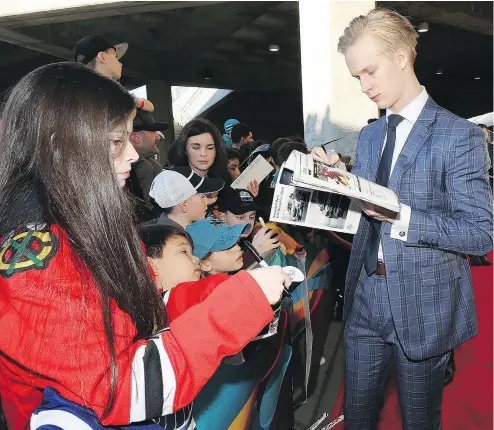  ?? — GETTY IMAGES ?? Vancouver’s Elias Pettersson, the runaway favourite for the Calder Trophy as rookie of the year, signs autographs and mingles with young fans at the 2019 NHL All-Star Red Carpet session on Friday in San Jose.