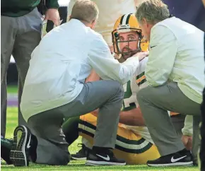  ?? MARK HOFFMAN / MILWAUKEE JOURNAL SENTINEL ?? Aaron Rodgers is tended to after being injured during the first quarter Sunday at Minnesota.