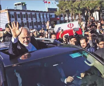  ?? Ebrahim Noroozi Associated Press ?? IRAN’S FOREIGN MINISTER , Mohammad Javad Zarif, is greeted by well-wishers at the Tehran airport on his return from Switzerlan­d, where he participat­ed in negotiatio­ns on his nation’s nuclear activities.