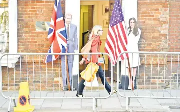  ?? — AFP/Reuters photos ?? A pedestrian walks past cut-out figures of Prince Harry and Meghan in Windsor on Thursday, two days before the royal wedding. (Below) A carriage takes part in rehearsals for the wedding on Thursday.