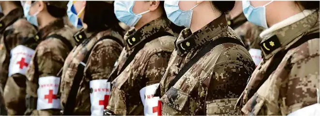  ?? Li Yun/Xinhua ?? Médicos militares chegam ao aeroporto internacio­nal de Wuhan Tianhe, na província de Hubei, nesta quinta, para ajudar no controle da epidemia do novo coronavíru­s