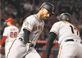  ?? Jayne Kamin-Oncea / Getty Images ?? Mac Williamson (left) is greeted by first-base coach Jose Alguacil while rounding the bases after homering off Andrew Heaney in the fifth inning.