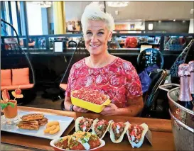  ??  ?? Bebeto Matthews / The Associated Press
Food Network star Anne Burrell shows off some of her creations for an all-Cheetos menu for a three-day pop-up restaurant in New York. The menu includes Cheetos meatballs, Cheetos crusted fried pickles, Cheetos...