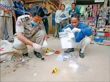  ?? HENG CHIVOAN ?? Authoritie­s bag evidence at a Battambang province medical centre after a large number of HIV cases in the area were uncovered.