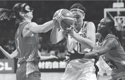  ?? JAVIER SORIANO / AFP / GETTY IMAGES ?? Team Canada forward Natalie Achonwa, centre, vies with Spain’s centre Laura Gil, left, and forward Astou Ndour Friday during the FIBA 2018 Women’s Basketball World Cup quarter-final match between Canada and Spain in San Cristobal de la Laguna on the Canary island of Tenerife.