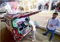  ?? AFP ?? Karrar Alaa (left) sells coffee by his travelling cafe vehicle in a street in Basra. —