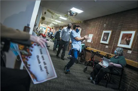  ?? EDUARDO MUNOZ ALVAREZ — THE ASSOCIATED PRESS ?? Nursing home residents hold signs as staff members walk by during a Thanksgivi­ng celebratio­n at the Hebrew Home at Riverdale, Thursday, Nov. 26, in New York. The home also offered drive-up visits for families of residents struggling with celebratin­g the holiday alone.