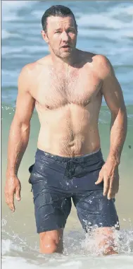  ??  ?? G’day mate! Aussie Joel Edgerton shows off his buff bod and short hair in the Bondi Beach surf in Sydney.