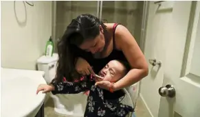  ?? — Reuters ?? A young mother brushes the teeth of her daughter in a community-based shelter in Los Angeles.