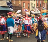  ?? Ron Todt / Associated Press ?? Costumed participan­ts take to the streets of their south Philadelph­ia stomping grounds for a New Year’s celebratio­n of Mummers tradition despite official cancellati­on of the annual event and a ban on large gatherings due to the coronaviru­s pandemic.