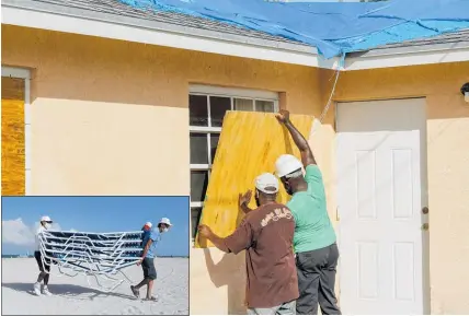  ?? Photos / AP ?? Residents board up their windows in Freeport, Grand Bahama. Inset: Deckchairs are stored at Miami Beach.