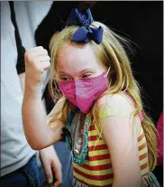  ?? MARSHALL GORBY / STAFF ?? Joy Minor, 9, shows off her muscles after receiving her COVID-19 vaccine Monday at Dayton Children’s Hospital.