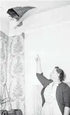  ?? BETTMANN ARCHIVE VIA GETTY IMAGES ?? Ann Hodges points to a hole in her Sylacauga, Ala. home ceiling where an approximat­ely 8 pound meteorite crashed through her roof, hit her radio and struck her on the hip as she was napping Nov. 30, 1954.