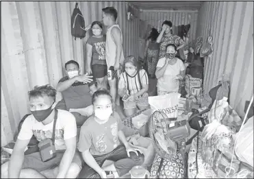  ??  ?? Locally stranded individual­s take shelter in a shipping container at the North Harbor in Manila yesterday. At least 100 LSIs, some of them returning overseas workers, were bound for Bacolod and Iloilo when the government suspended travel to the Western Visayas for two weeks, starting on Saturday, after local officials complained that their isolation facilities are filled beyond capacity. EDD GUMBAN