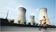  ?? — Reuters ?? A woman cycles past coal-powered plants in Beijing, in this file photo.