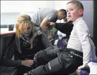  ??  ?? Sarah Hutton helps her son Chase Hutton, 7, take off his hockey gear Feb. 25 at Las Vegas Ice Center. Nevada had only 1,342 registered youth players in 2016, according to USA Hockey.